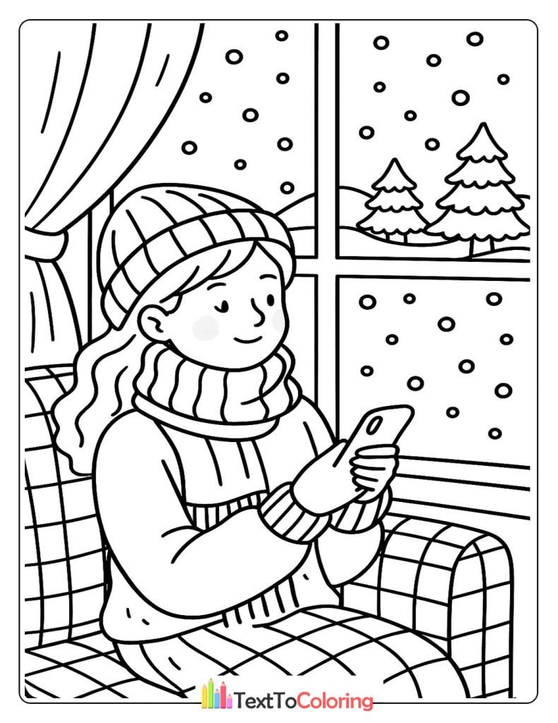 A girl wearing a hat and scarf sits by a window and looks at her phone while it snows outside.