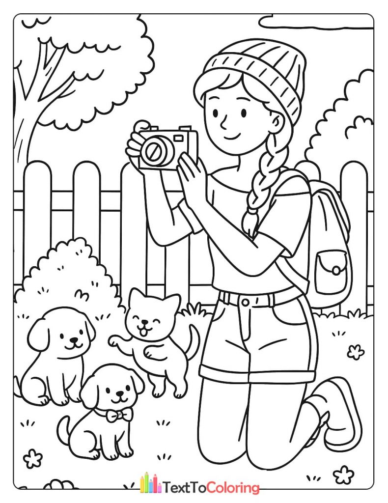 A person kneels to take a photo of a kitten and two puppies in a yard.